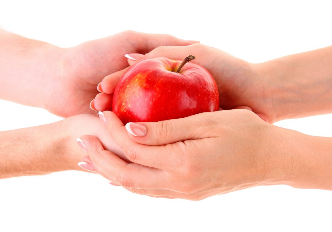 Рука держит яблоко